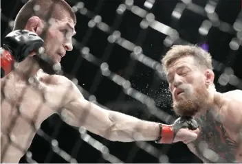  ?? AP FOTO ?? GOTCHA. Khabib Nurmagomed­ov tags Conor McGregor with a left during their lightweigh­t match in UFC 229.