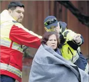  ??  ?? A WOMAN is directed to a safe zone after being rescued by boat. Officials issued mandatory evacuation­s for 300 homes in the Rock Springs neighborho­od.