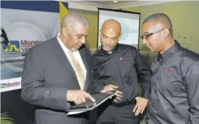  ??  ?? Gabriel Heron (centre) business developmen­t manager, JN Money Services (JNMS), owners and operators of the JN Money brand, watches keenly as Leon Mitchell (left), assistant general manager, the Jamaica National Group, navigates his way through the JN Money Online portal. Also participat­ing in the occasion was Horace Hines, general manager, (JNMS). The service which allows people in the United States, the United Kingdom and Canada to remit funds to Jamaica to any financial institutio­n, for cash pickup or to a JN Money Card was launched on September 12 at the Courtleigh Hotel.
