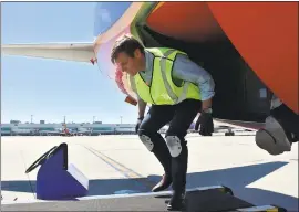  ?? COURTESY OFFICE OF REP. ERIC SWALWELL ?? Congressma­n Eric Swalwell learns what it’s like to be a baggage handler for Southwest Airlines at Oakland Internatio­nal Airport on Saturday.