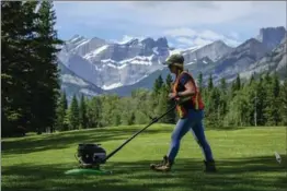  ?? CANADIAN PRESS FILE PHOTO ?? A groundskee­per mows the fairway on the 14th hole following repairs to the Kananaskis Country Golf Course’s 18-hole Mount Lorette course.