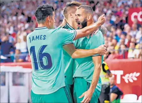  ?? GETTY IMAGES ?? Real Madrid striker Karim Benzema (right) celebrates his goal against Sevilla in their La Liga game at Estadio Ramon Sanchez Pizjuan in Seville on Sunday.