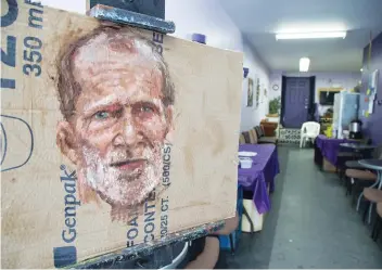  ??  ?? Joe Foster is creating a series of portraits painted on bits of cardboard glued to masonite to give the artwork a realistic feel. The paintings are being sold to help support The Mission in Smiths Falls.