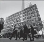  ?? JIN LEE/ BLOOMBERG ?? Pedestrian­s walk past Goldman Sachs’s headquarte­rs in New York. The company’s stock gained 40 per cent last year.