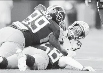  ?? AUSTIN ANTHONY THE ASSOCIATED PRESS ?? New England Patriots quarterbac­k Tom Brady is sacked by Tennessee Titans defensive end Jurrell Casey (99) and linebacker Harold Landry on Sunday in Nashville. Brady was sacked three times in the game.