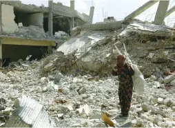  ?? (Aboud Hamam/Reuters) ?? A WOMAN GESTURES earlier this month as she stands among rubble from damaged buildings in Raqqa, Syria.