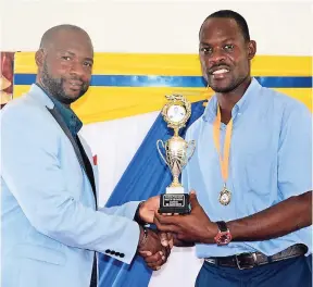  ?? GILCHRIST PHOTO BY CARL ?? Parent of the Year, David White (right), collects his trophy from Pastor Paul Hemmings.