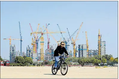  ?? AP/ANDY WONG ?? A man passes a constructi­on site near Olympic Park in Beijing last week. The Internatio­nal Monetary Fund expects China, the secondbigg­est economy, to post faster growth this year for the first time since 2010.