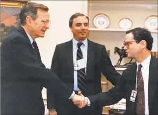 ?? The White House / Contribute­d photo ?? Dan Freedman, right, greets President George H.W. Bush at an Oval Office interview in 1992. Hearst Washington Bureau chief Chuck Lewis is at center.