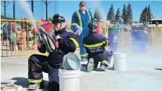  ?? PHOTO: POTASHCORP ?? Team members from PotashCorp’s Patience Lake mine readying fire extinguish­ers.