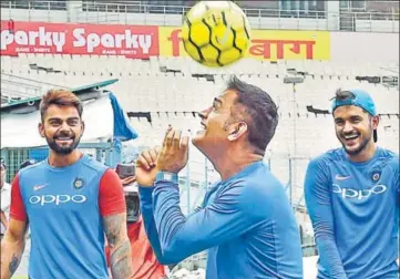  ?? PTI ?? India captain Virat Kohli (left) and Manish Pandey look on as MS Dhoni plays with a football at Eden Gardens in Kolkata. Both India and Australia couldn’t train on Wednesday due to damp outfield.