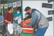  ??  ?? Organizers prepare packages of items to be delivered to
customers.