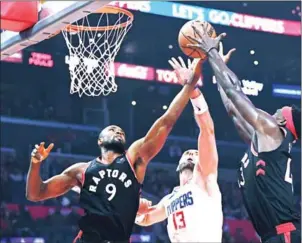  ?? HARRY HOW/GETTY IMAGES/AFP ?? Marcin Gortat (centre) of the LA Clippers jumps between Serge Ibaka (left) and Pascal Siakam of the Toronto Raptors at Staples Center on Tuesday.