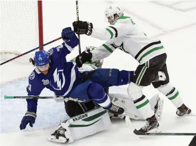  ?? CANADIAN PRESS VIA AP
FOTO: JASON FRANSON/THE ?? Dallas Miro Heiskanen trycker ner Tampa Bays Brayden Point, över sin egen målvakt.