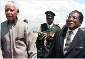  ??  ?? With Nelson Mandela in 1998. South Africa consistent­ly refused to rein in Mugabe