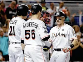  ?? LYNNE SLADKY / ASSOCIATED PRESS ?? Miami’s Derek Dietrich (right) ismet by Christian Yelich and Brian Anderson on Saturday night after hitting a three-run homerun during the fifirst inning against the Braves. TheMarlins scored fifive in the inning.