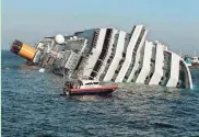  ?? ASSOCIATED PRESS ?? A boat approaches the luxury cruise ship Costa Concordia, which ran aground off the coast of Tuscany.