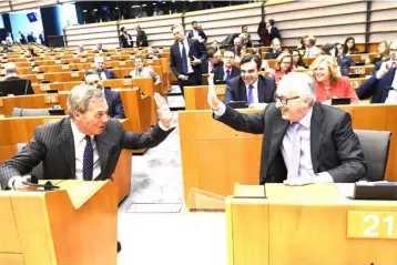  ??  ?? European Commission President Jean-Claude Juncker (right) and Brexit campaigner and member of the European Parliament Nigel Farage exchange a ‘high five’ gesture, at the start of the plenary session on the EU’s next long-term budget, in the European...