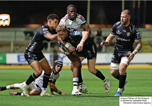  ?? ?? Angus O’Brien of the Dragons is tackled by Aphelele Fassi
Pictures: Huw Evans Agency