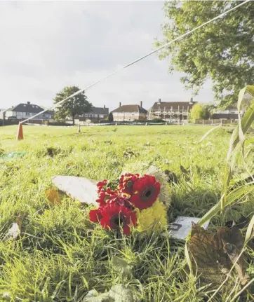  ?? ?? SCENE: Flowers at cordoned off parkland on the Stoney Lane estate, Lightcliff­e. The body of 52-year-old Dawn Walker was discovered near Aysgarth Avenue on Sunday. A man has been charged with murder.