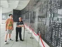  ?? HUANG LERAN / FOR CHINA DAILY ?? Wang Jiangang (right), the second-generation keeper of the Red Army Martyrs Cemetery of the Sichuan-Shaanxi Soviet Area, tells revolution­ary stories to a young visitor in front of a wall of martyrs’ names in Wangping village of Tongjiang, Sichuan province, in June.