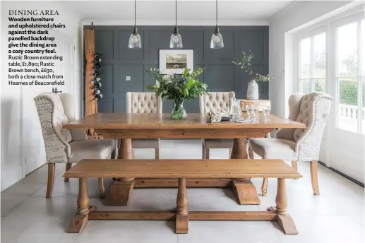  ??  ?? DINING AREA Wooden furniture and upholstere­d chairs against the dark panelled backdrop give the dining area a cosy country feel. Rustic Brown extending table, £1,890; Rustic Brown bench, £630, both a close match from Hearnes of Beaconsfie­ld