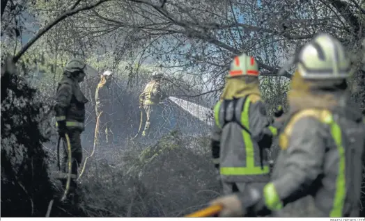  ?? BRAIS LORENZO / EFE ?? Cinco bomberos realizan labores de extinción de un fuego en Orense.