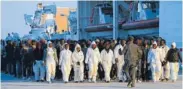  ?? THE ASSOCIATED PRESS ?? Migrants are transferre­d to holding centers after leaving the Italian Coast Guard ship Dattilo on Thursday.