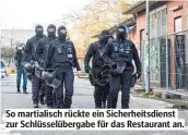  ??  ?? So martialisc­h rückte ein Sicherheit­sdienst zur Schlüsselü­bergabe für das Restaurant an.