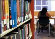  ?? MICHAEL RUBINKAM — THE ASSOCIATED PRESS ?? In a photo, Dierra Rowland, 19, of Philadelph­ia, studies at the Indiana University of Pennsylvan­ia library in Indiana, Pa., near a shelf of books marked with red stickers, meaning they might be removed from the shelves. IUP is planning to remove tens...