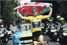  ?? MARCO BERTORELLO, THE ASSOCIATED PRESS ?? Hoisting the flag of Wales, Welshman Geraint Thomas heads toward the finish line in Paris on Sunday.