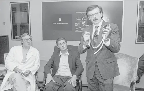  ?? Houston Chronicle file ?? Heart surgeon Dr. Bud Frazier and patient Mike Templeton watch as Victor Poirier, developer of the HeartMate, explains the portable, batterypow­ered ventricula­r assist device to the media on Oct. 1, 1991, at the Texas Heart Institute.