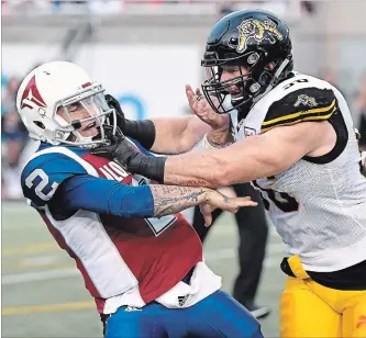  ?? PAUL CHIASSON THE CANADIAN PRESS ?? Alouettes quarterbac­k Johnny Manziel, left, is hit by Hamilton Tiger-Cats defensive end Jason Neill during first-quarter action in Montreal on Friday night. Hamilton won easily, 50-11.