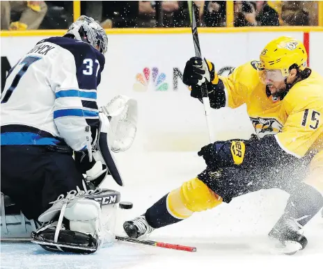  ??  ?? Winnipeg goalie Connor Hellebuyck was a wall in net Friday, stopping Craig Smith and almost every other Nashville player in a 4-1 Jets victory. Hellebuyck’s 47 saves guided the Jets to a 1-0 series lead over the Preds, with Game 2 set for Sunday. MARK...