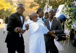  ?? AP ?? The relative of a killed police officer cries at the funeral for three officers killed in the line of duty in the Petion-ville district of Port-au-prince, Haiti.