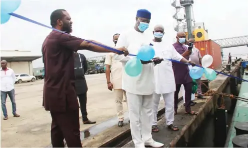  ??  ?? MD NIWA cutting tape to commission the Onitsha River port