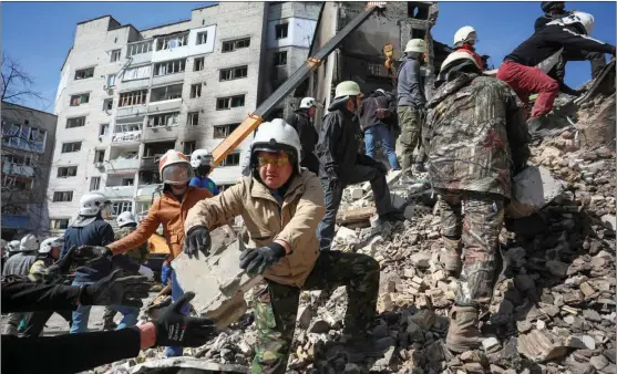  ?? ALEKSEY FILIPPOV / AFP ?? Volunteers help rescuers remove the rubble from a building that was struck in the town of Borodianka, northwest of Kyiv, on April 7.