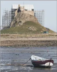  ??  ?? A canvas cover has been put in place to enclose the temporary roof installed during restoratio­n works at Lindisfarn­e Castle on Holy Island. Lindisfarn­e Castle was built in 1550.
