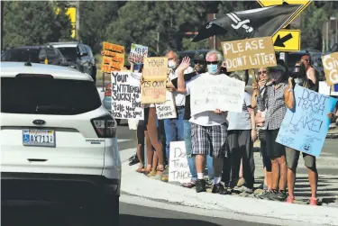  ?? Carlos Avila Gonzalez / The chronicle ?? Protesters hold signs discouragi­ng tourism as a line of cars arrives in the area coming in on Highway 50.