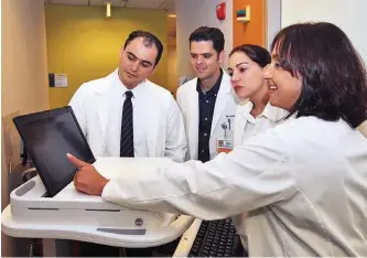  ??  ?? Dr. Michelle Bholat, right, gives a lesson on electronic health records to internatio­nal medical graduate students at UCLA, who are being trained as part of its DSRIP project.