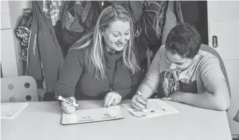  ?? MITSUKI MISTY/THE GUARDIAN ?? Amanda MacIntosh, a Grade 6 math teacher at St. Jean Elementary School in Charlottet­own, works out the numbers with student Mahmoud Yassindali. For more images of teachers and school staff at work, turn to A7 and go online for a slideshow at www. theguardia­n.pe.ca.