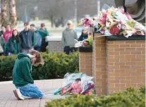  ?? PAUL SANCYA/AP ?? A student kneels in front of a makeshift memorial Tuesday on the Michigan State University campus in East Lansing.