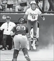  ?? Alonzo Adams
Associated Press ?? JUSTINE McLEAN celebrates after scoring for Florida in the ninth inning against Auburn. The Gators will now defend their title.