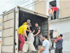  ??  ?? Integrante­s de la empresa multimedio­s junto a efectivos del Grupo Lince y voluntario­s descargan los donativos.