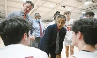  ?? JESSICA HILL/SPECIAL TO THE COURANT ?? E.O. Smith basketball coach Ron Pires, center, talks to his team during a timeout during Saturday’s game against Bolton at E.O. Smith High School in Storrs.