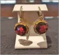  ??  ?? Among the items up for bid is this pair of 14-karat yellow gold garnet and diamond earrings. Buyers can choose from local or national charities to benefit from their purchases.