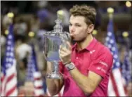  ?? DARRON CUMMINGS — THE ASSOCIATED PRESS ?? Stan Wawrinka holds up the championsh­ip trophy after beating Novak Djokovic to win the men’s singles final of the U.S. Open Sunday in New York.