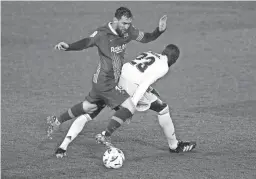  ??  ?? Barcelona’s Lionel Messi, left, vies for the ball with Real Madrid’s Ferland Mendy on April 10 in Madrid. Real Madrid won 2-1.