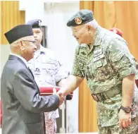  ??  ?? ZULKIFLI semasa menyampaik­an pingat kepada salah seorang anggota veteran ATM.