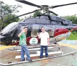  ??  ?? JAKARTA: This handout photo released by Grab Indonesia yesterday shows Ridzki Kramadibra­ta (left), managing director of online ride-hailing firm Grab Indonesia, posing with a customer (right) prior to taking a helicopter taxi by Grab Indonesia in...